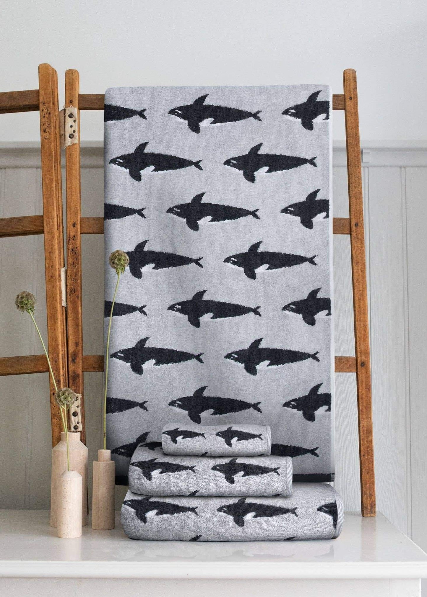 Gray towel with black shark pattern on a wooden rack