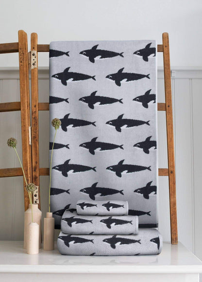 Gray towel with black shark pattern on a wooden rack