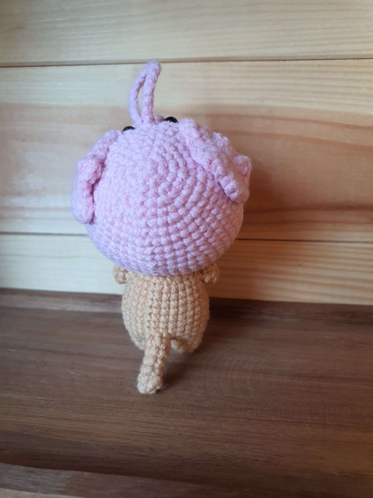 Crocheted mushroom toy on a wooden surface