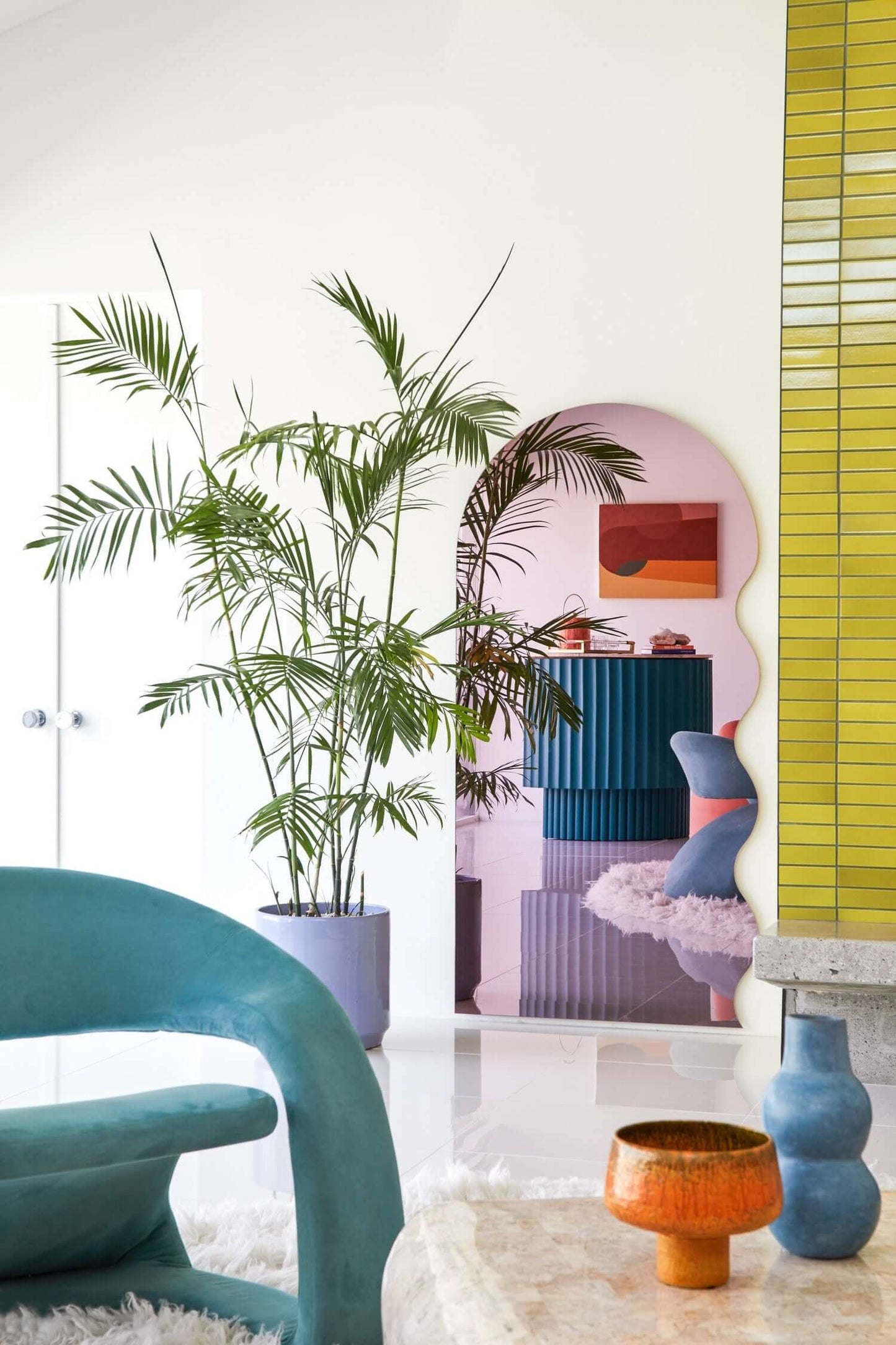 House of Joy playful interior design featuring vibrant colors, curvy shapes, and lush greenery in a modern setting.
