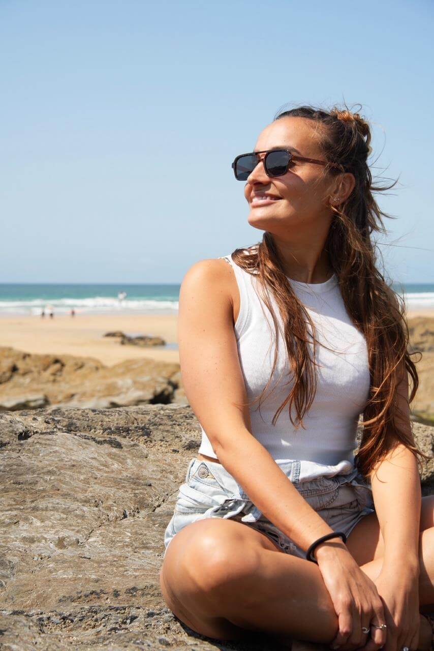 Luma Sunglasses - Bantham - Tortoise worn by a woman on a beach enjoying sunny weather, ideal for eco-friendly online shop UK.