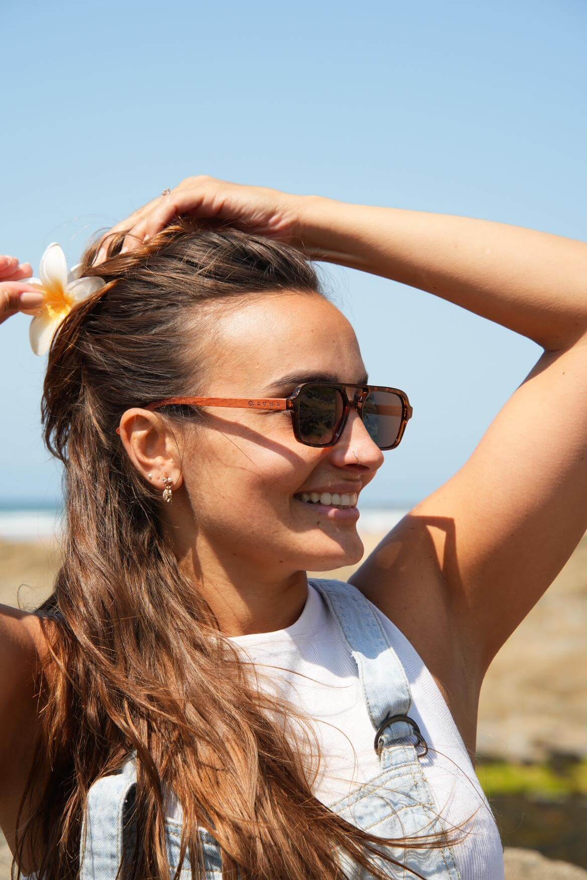 Luma Sunglasses - Bantham - Tortoise being worn by a woman with a flower in her hair at the beach.