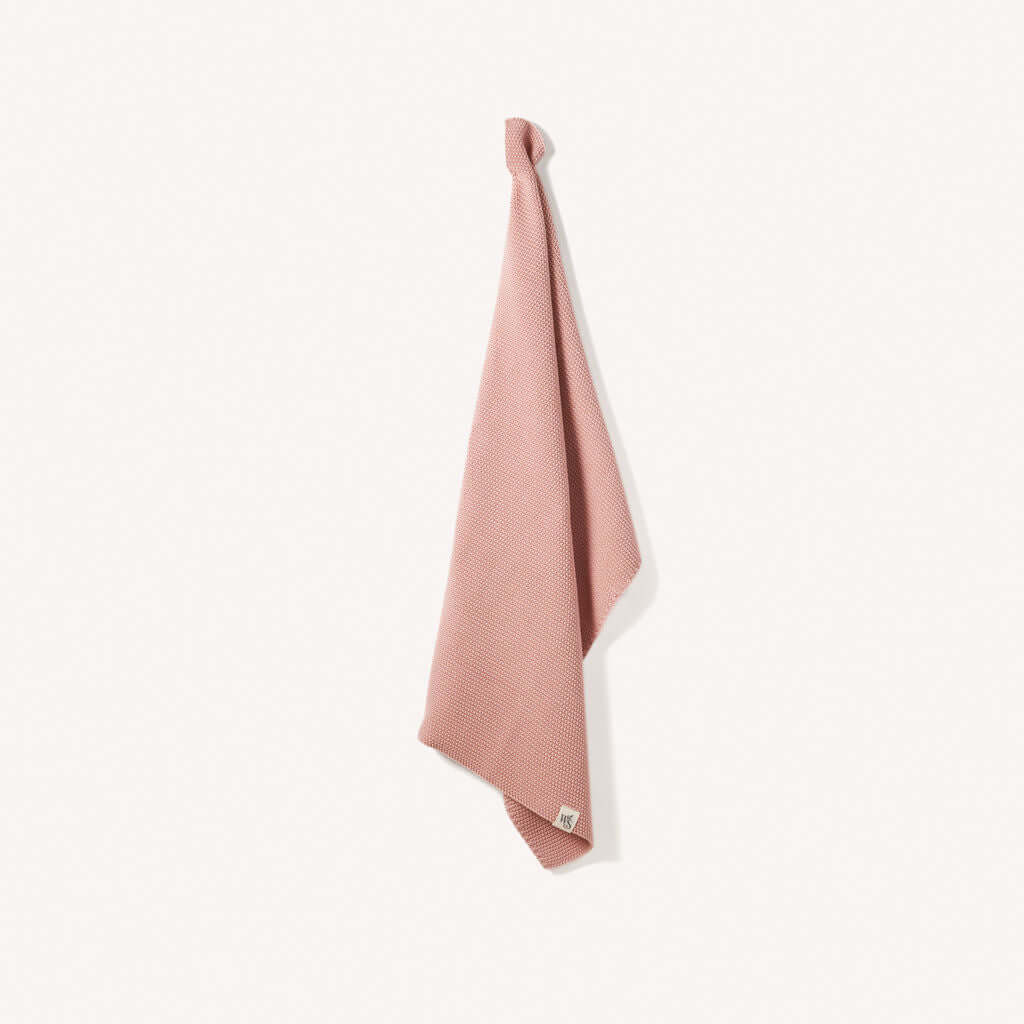 Organic Cotton Hand Towels in soft pink hanging on a hook, perfect for drying hands and eco-friendly.