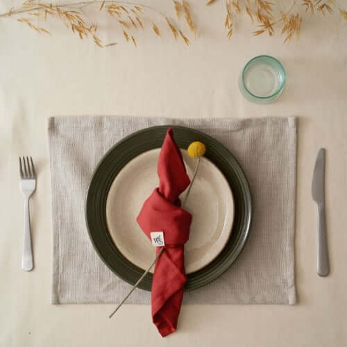 Organic Cotton Napkins - Set of 4 elegantly displayed on a table setting with a plate and cutlery.