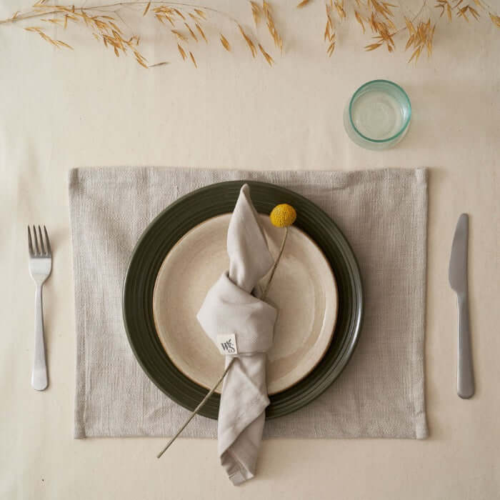 Organic Cotton Napkins - Set of 4 elegantly displayed on a dinner plate with utensils and a decorative flower.