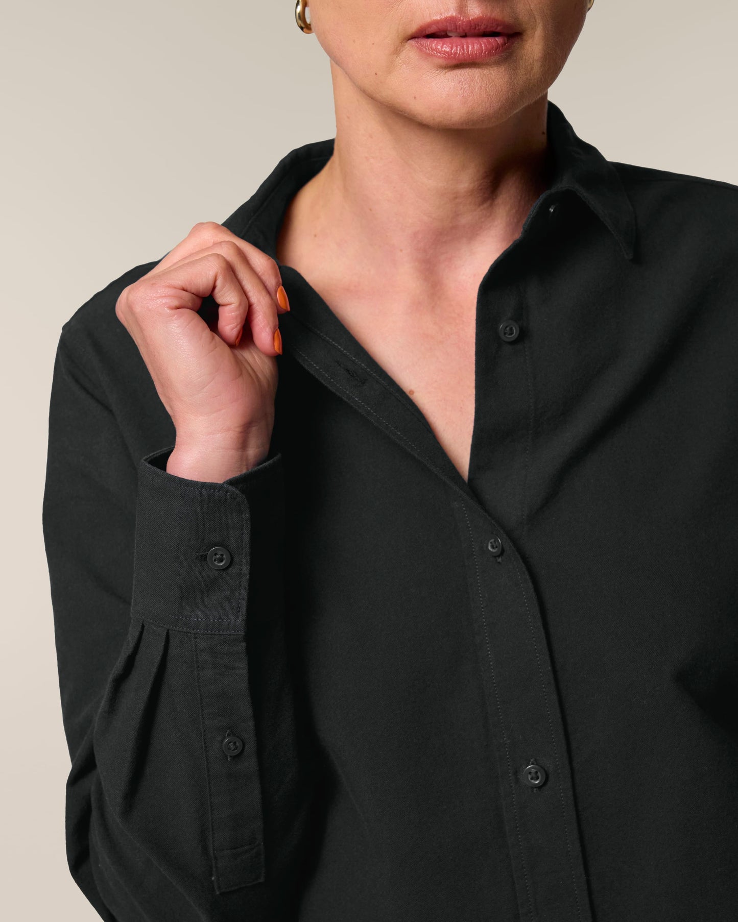Close-up of a woman showcasing the Organic Cotton Oxford Long Sleeve Shirt: Womens with a buttoned collar.