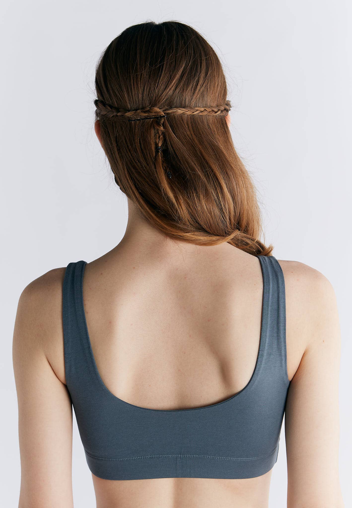 Back view of a model wearing an Organic Cotton Padded Bralette, showcasing its wide straps and soft fabric.