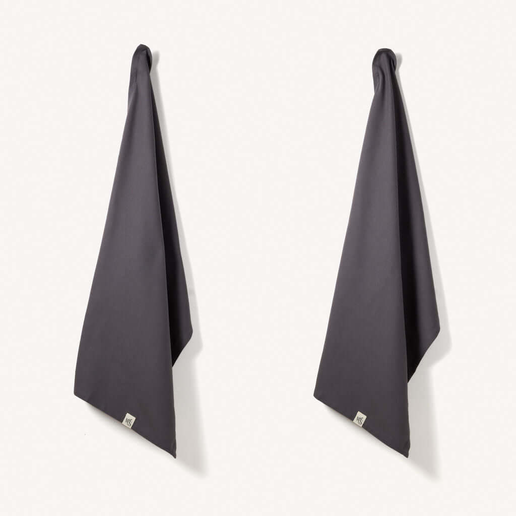 Organic Cotton Tea Towels - Herringbone Weave - Set of 2 hanging in a kitchen, featuring a stylish dark design.