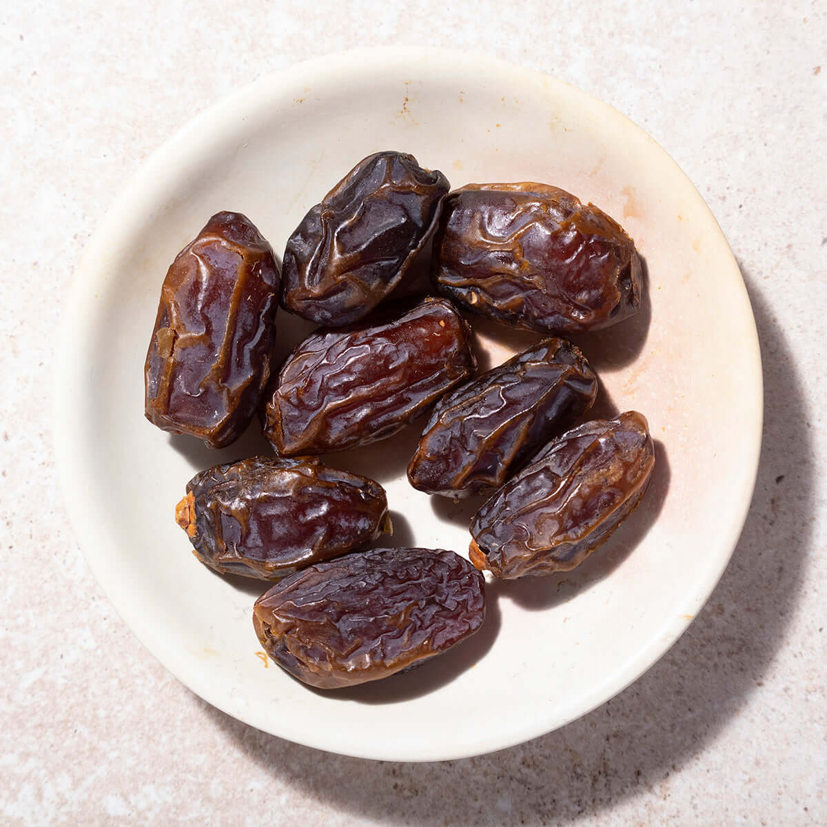 Date fruits on a white plate with a light background