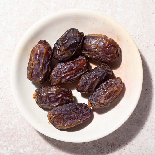 Date fruits on a white plate with a light background