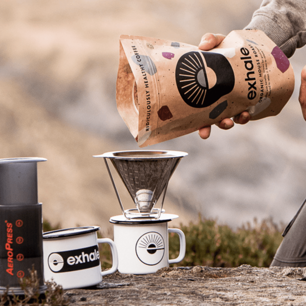 Organic House Roast Coffee being prepared with an AeroPress, showcasing Exhale Healthy Coffee packaging.