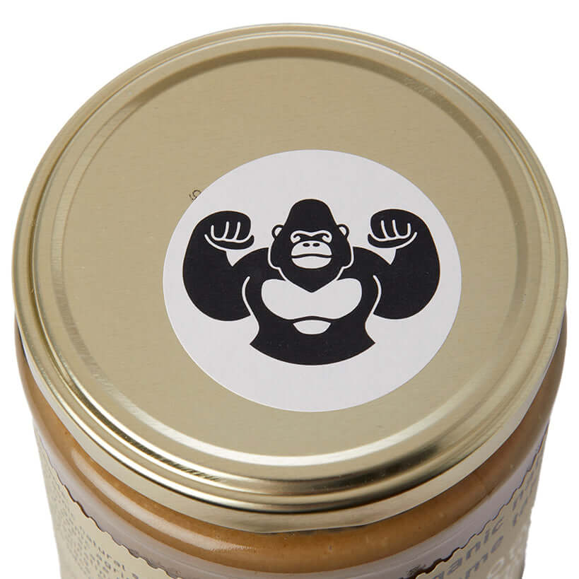 Gold jar lid with a gorilla logo on a white background