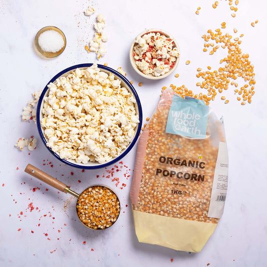 Organic Popcorn - Delicious & Non-Perishable Snack in a vibrant bowl with kernels and seasonings on a marble surface.