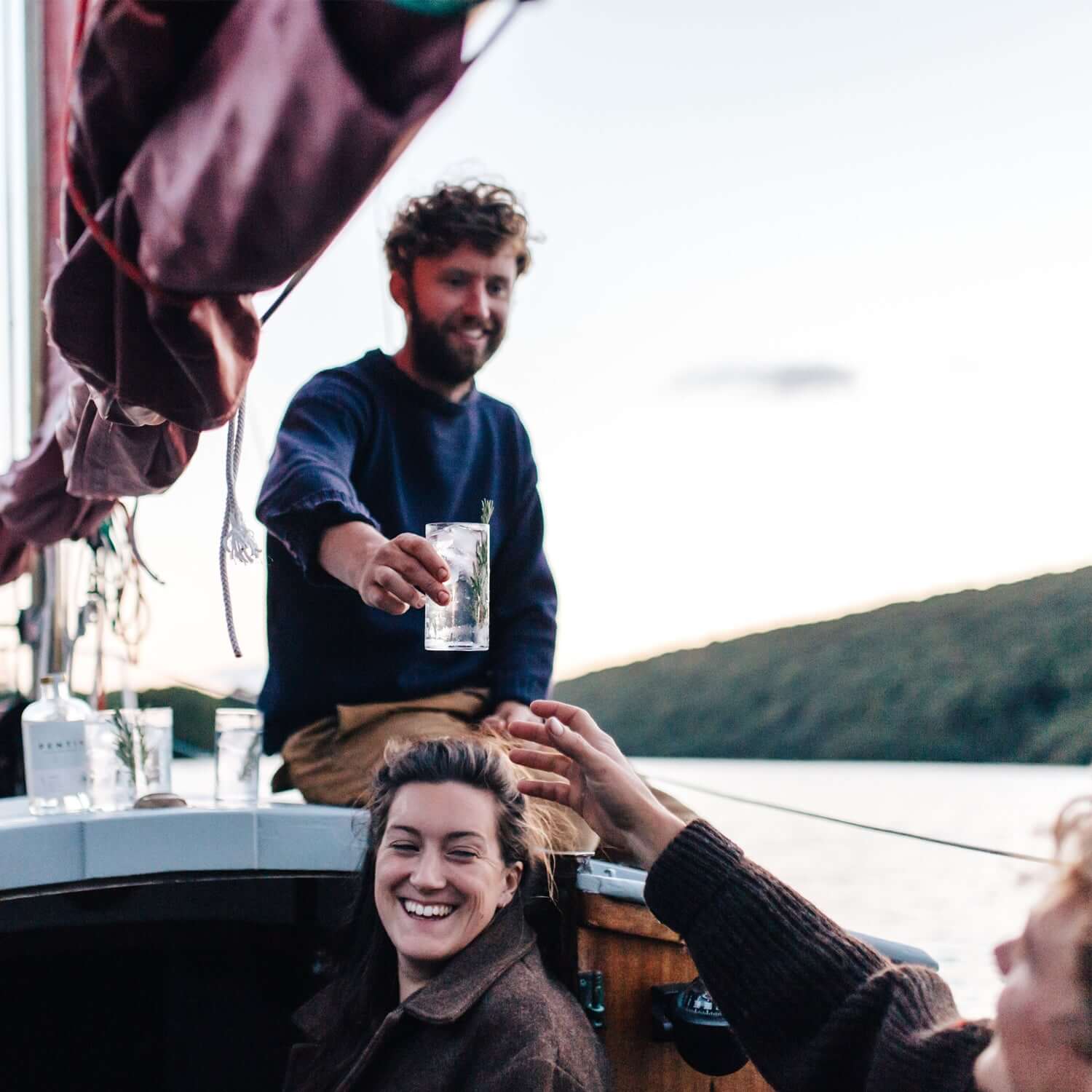 Pentire Adrift enjoyed on a boat at sunset, showcasing a refreshing non-alcoholic spirit experience.