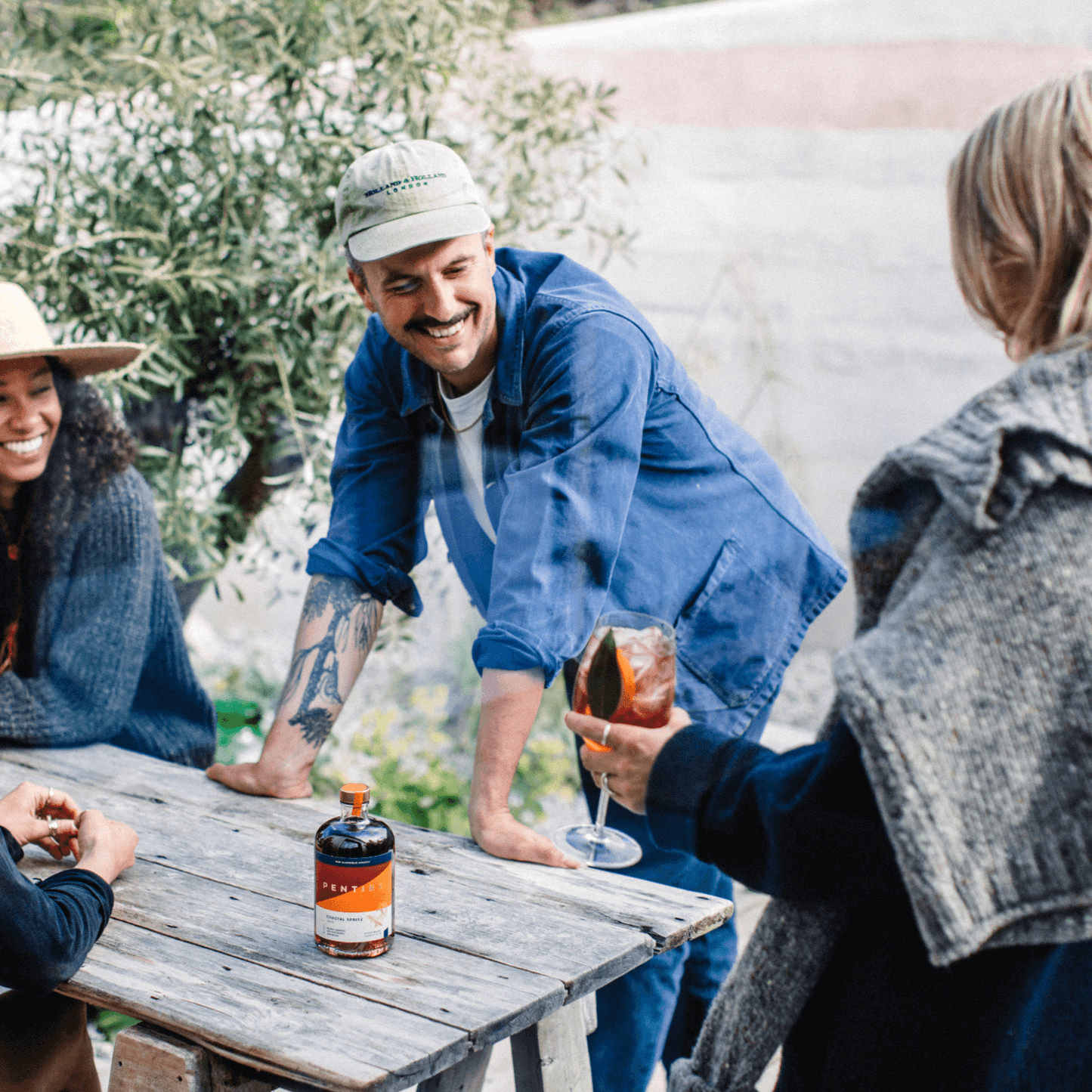 Group enjoying Pentire Coastal Spritz in a garden setting, showcasing a refreshing non-alcoholic aperitif.