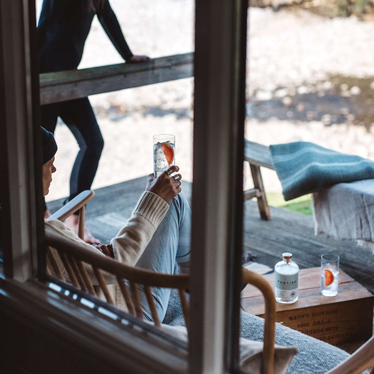 Pentire Seaward non-alcoholic spirit enjoyed on a cozy deck with coastal views and refreshing garnishes.
