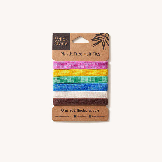 Set of colorful plastic-free hair ties on a cardboard packaging with 'Wild & Stone' branding.