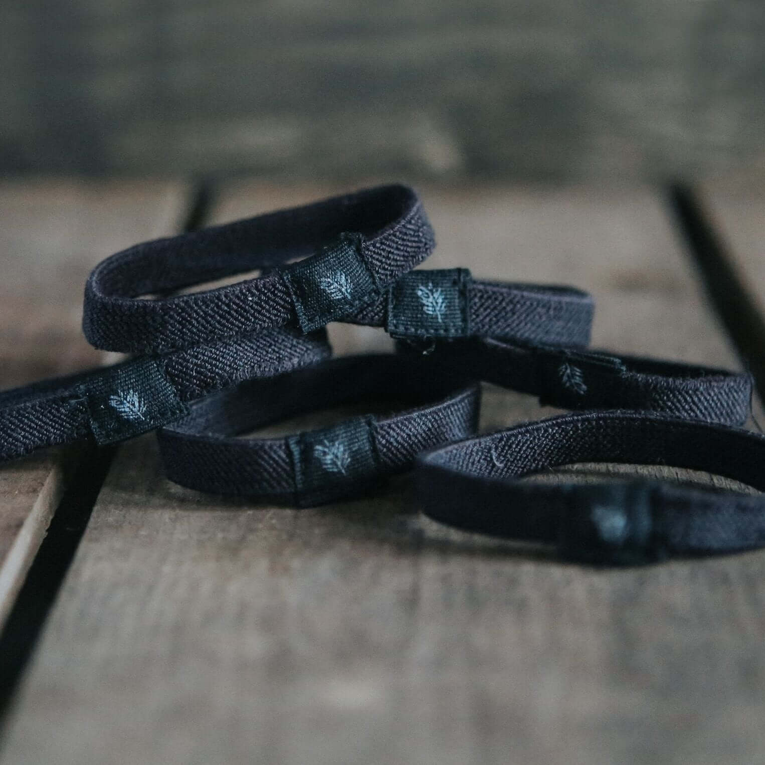 Black woven straps on a wooden surface