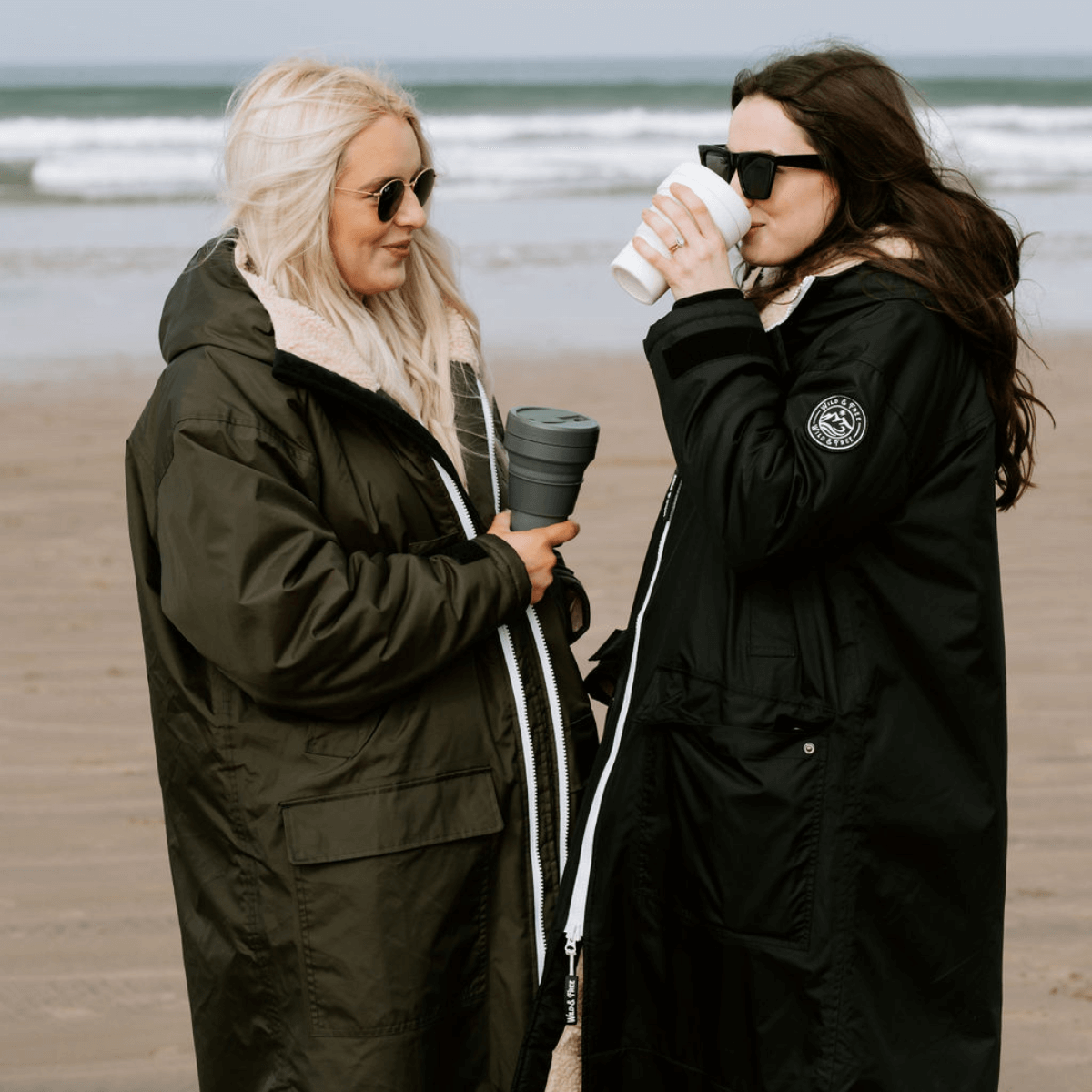 Raincoat & Changing Robe in One - The Classic Cobe Olive Green worn by two women at the beach.