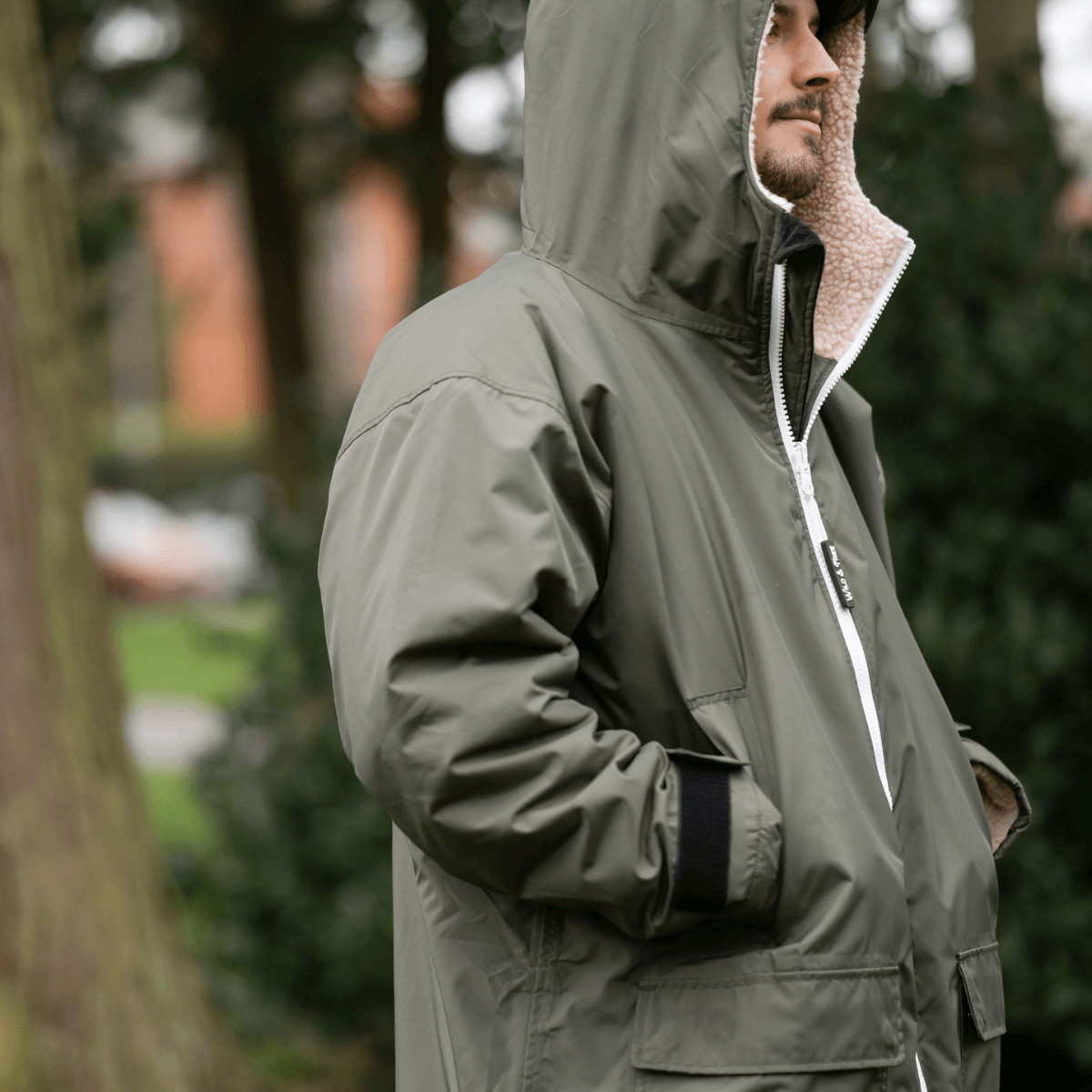 Raincoat & Changing Robe in One - The Classic Cobe Olive Green, stylish and functional in outdoor setting.