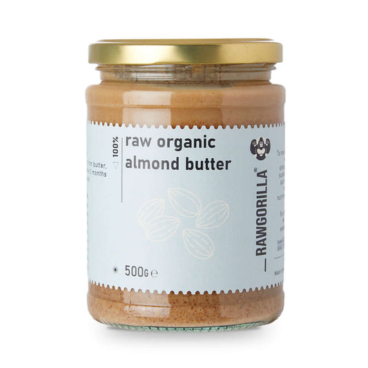 Jar of raw organic almond butter with a gold lid on a white background