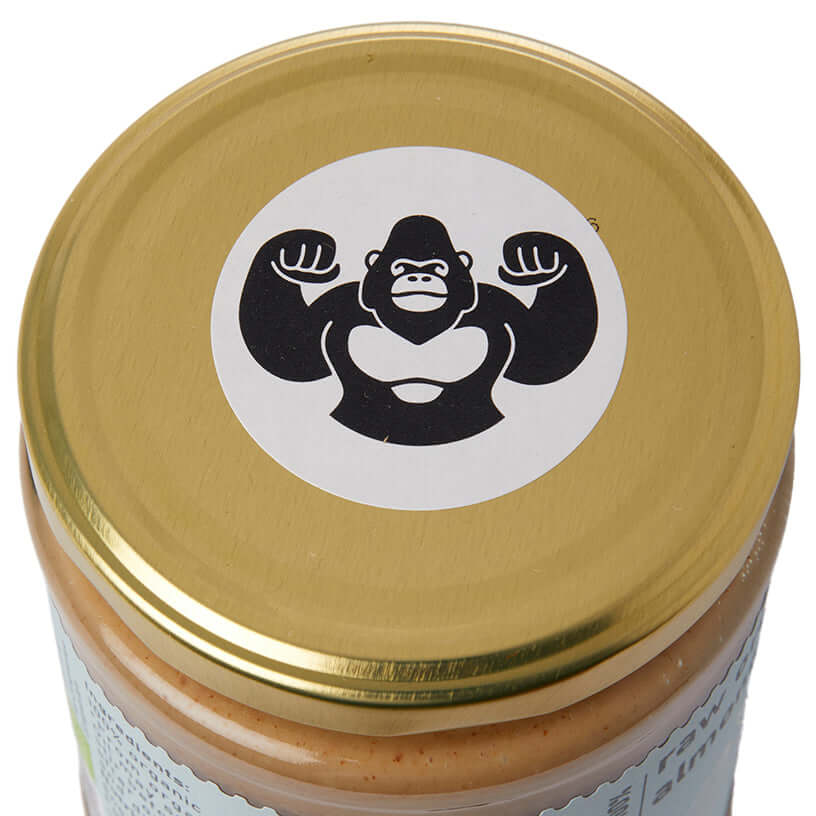 Gold lid of a jar with a gorilla logo on a white background