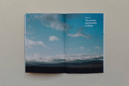 Open book page showing sky with clouds and text on the science and benefits of Vedic Meditation.