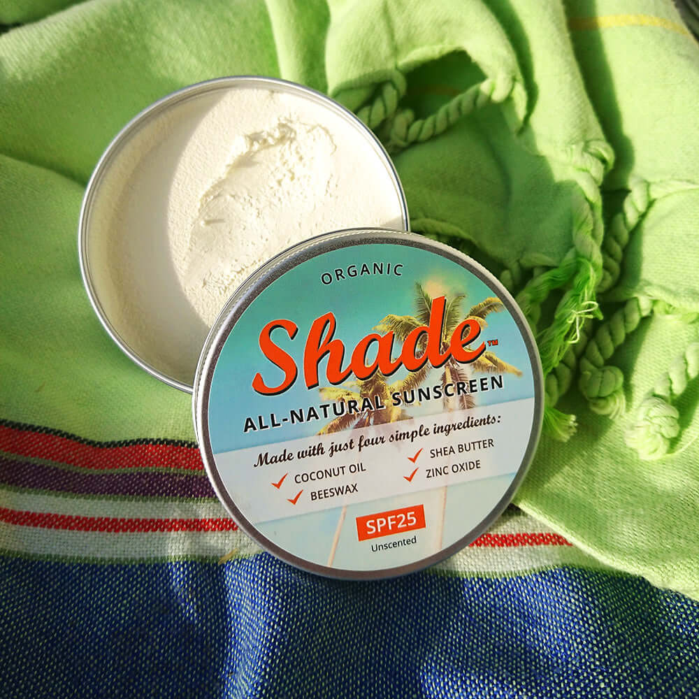 Container of Shade all-natural sunscreen on a colorful fabric background