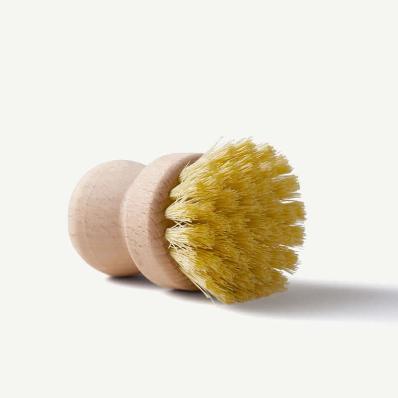 Wooden dish brush with yellow bristles on a white background