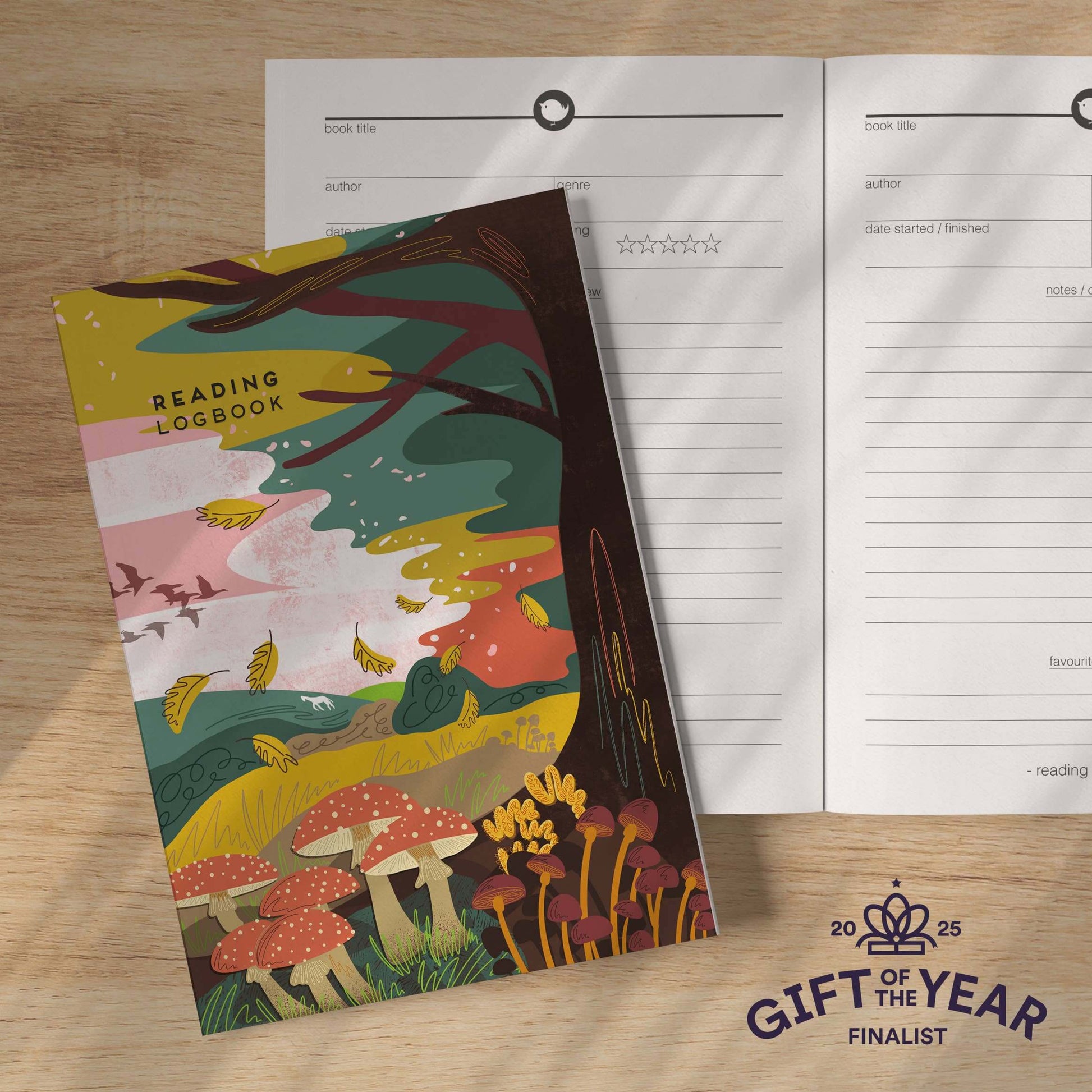 Reading logbook with colorful mushroom design on a wooden surface