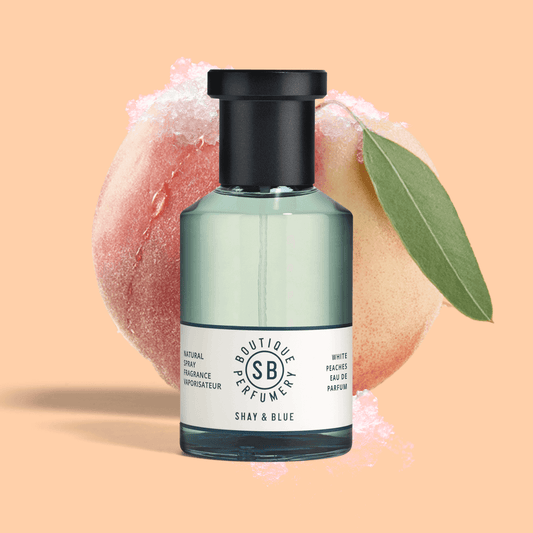 White Peaches Fragrance 100ml bottle with a peach slice and soft background for a refreshing summer scent.