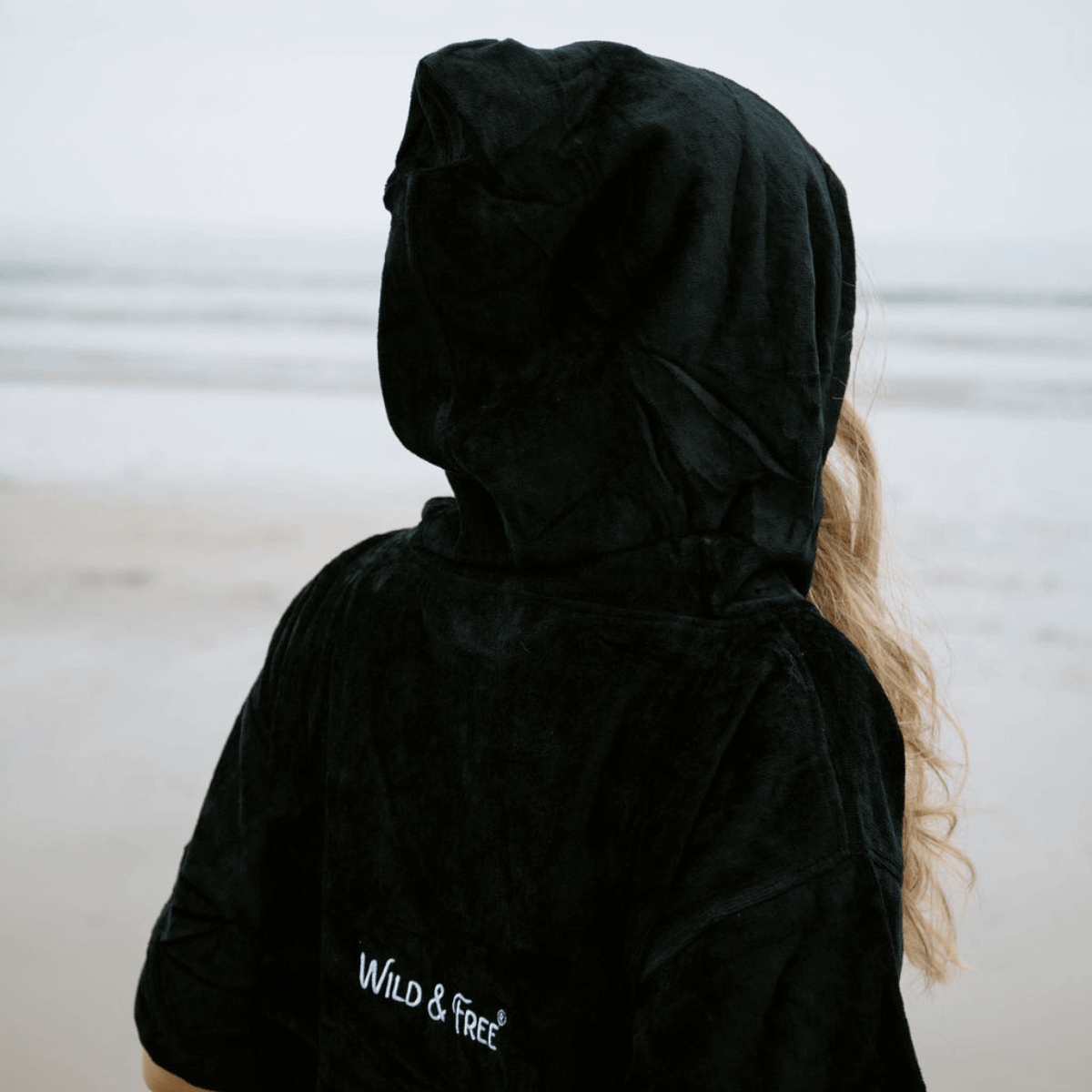 The Luxury Towel Robe with hood in black, perfect for beach, ice bath, or poolside lounging by Wild & Free.