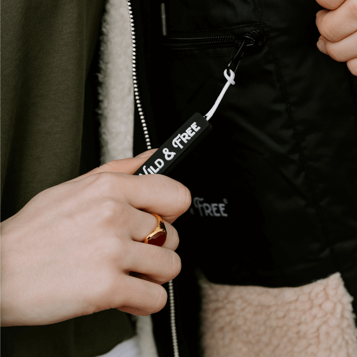 Detail of the zipper pull on the Raincoat & Changing Robe in One - The Classic Cobe Black from alewk.club.