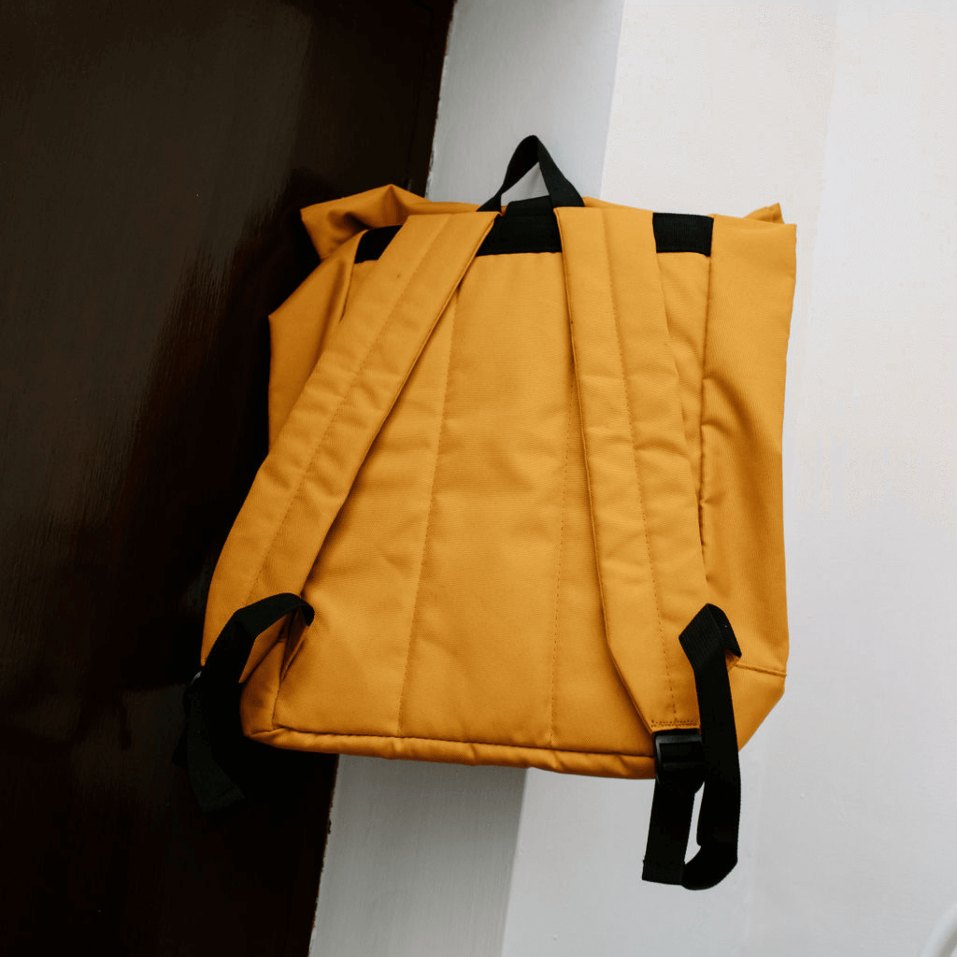 The Backpack in classic yellow color with padded straps, perfect for adventures. Shop at Alewk.club.