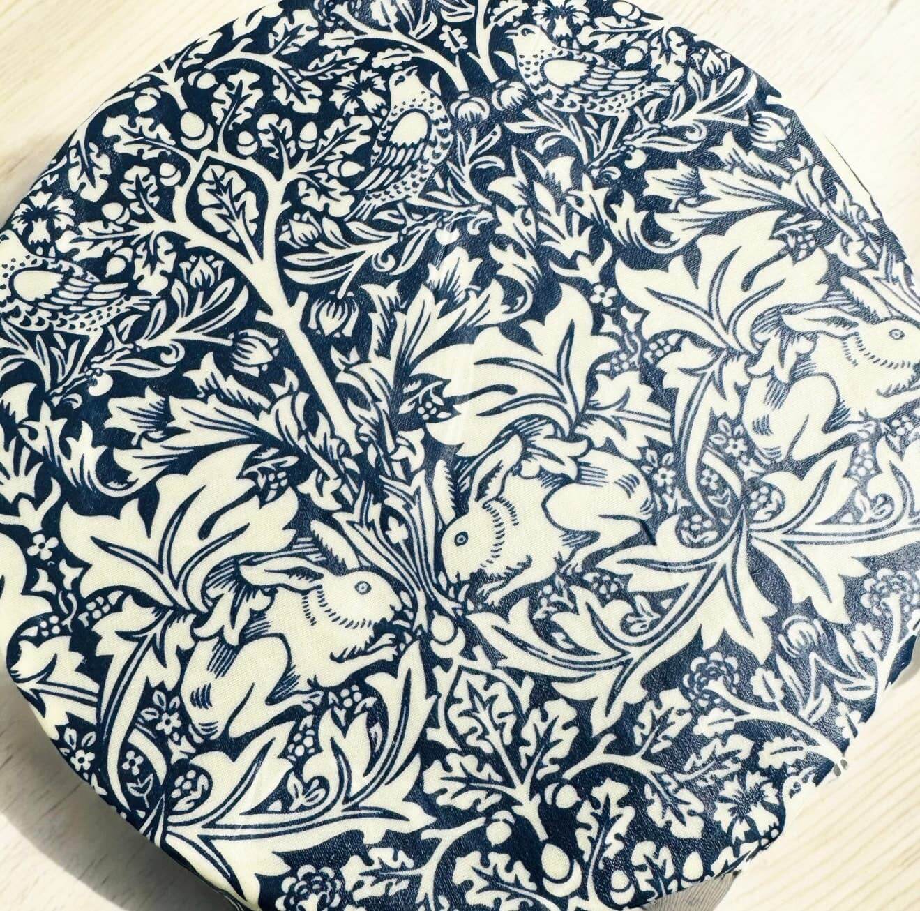 Decorative plate with intricate blue and white floral and animal pattern on a wooden surface