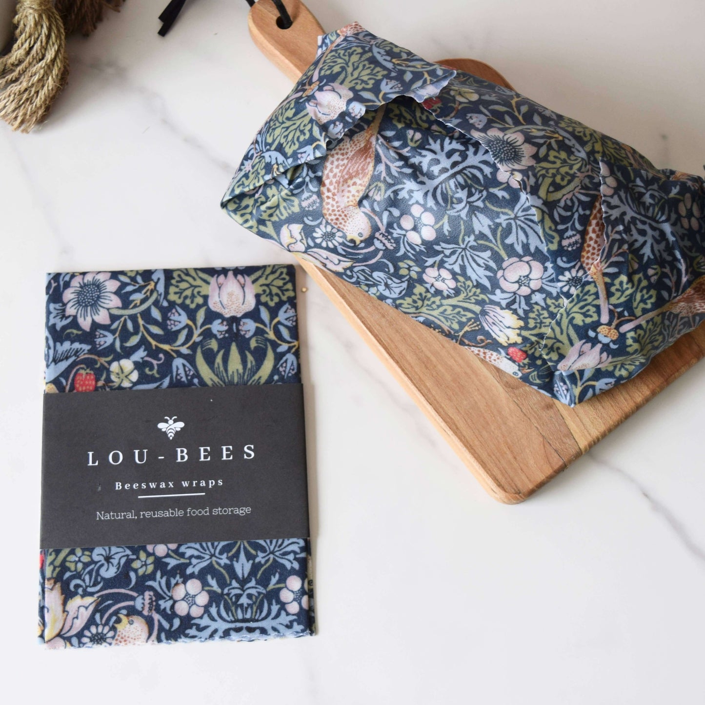 Lou-Bees beeswax wraps with floral design on a wooden board and white background